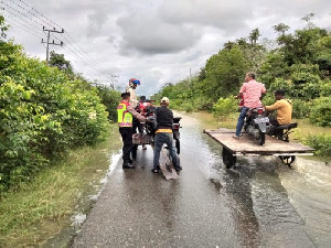 Jalan Tertutup Banjir, Personel Polsek Bubon Bantu Warga Seberangkan Motor